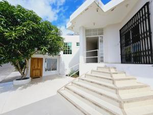 a white house with stairs and a tree at Suite para parejas in Puerto Baquerizo Moreno