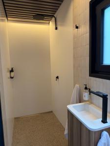 a bathroom with a sink and a shower at Chapel Cove Retreat - Private Tiny House with Boat Ramp in Sackville Reach