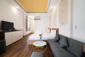 a living room with a bed and a couch at Rocky Hotel Ho Chi Minh in Ho Chi Minh City