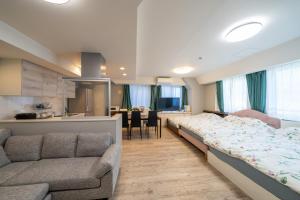 a bedroom with a bed and a couch and a kitchen at 目白 Yoko hotel shinnjuku, shinokubo 10 people stay, big room in Tokyo