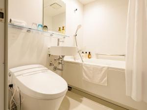 Un baño blanco con inodoro y bañera. en Hotel Espasion Pontocho, en Kioto