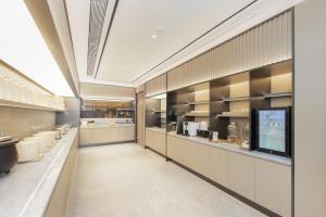 una cucina con mobili bianchi e una grande finestra di JI Hotel Shanghai South Railway Station Jinjiang Amusement Park (formerly Jinjiang Amusement Park Subway Station Branch) a Shanghai