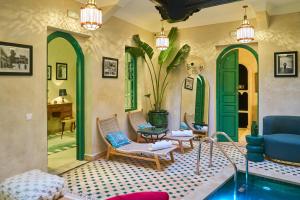 a living room with a blue couch and chairs at Riad Lia ou Lik in Marrakesh