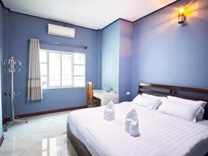 a bedroom with a large bed with shoes on it at GRAD Miksoxy Hotel Vang Vieng in Vang Vieng +50 photos