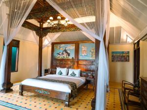a bedroom with a large bed with a canopy at Villa Borobudur Resort in Borobudur +64 photos