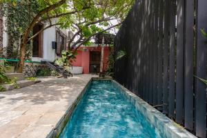 a swimming pool in front of a house with a fence at Alko Hotel Casa Nispero in Cali