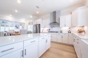 a white kitchen with white cabinets and a table at Happily Eva After at Prominence 30A in Inlet Beach