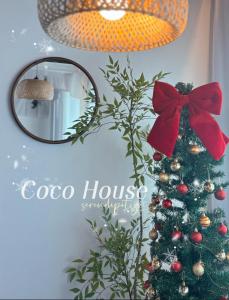 テジョンにあるCoco Houseの鏡の横にある赤いリボンのついたクリスマスツリー