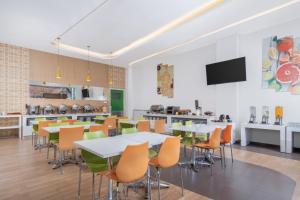 a cafeteria with tables and chairs and a kitchen at Indies Style Malioboro Hotel in Yogyakarta