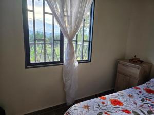 a bedroom with a bed and a window at Finca La Preciosura in Horizonte