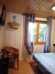 a bedroom with a bed and a window at ZEcamping 4 étoiles pet friendly piscine et pétanque au cœur des Alpilles in Noves