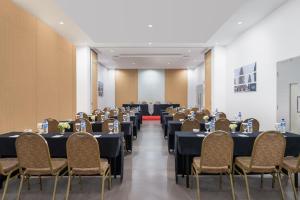 a banquet hall with tables and chairs in a room at Indies Style Malioboro Hotel in Yogyakarta +14 photos