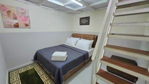 a small room with a bed and a ladder at Homestay BAYT AL - JAZMY in Kuantan