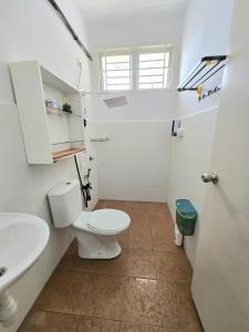 a white bathroom with a toilet and a sink at Homestay BAYT AL - JAZMY in Kuantan