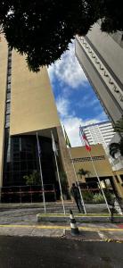 a building with three flags in front of it at Flat 502 América Tower, ao lado do Salvador Shopping in Salvador