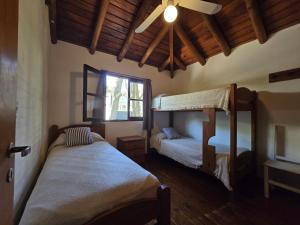 een slaapkamer met twee bedden en een plafondventilator bij Medanos in Las Gaviotas