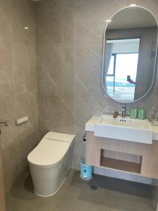 a bathroom with a toilet and a sink and a mirror at 2BR Cozy Apartment- River and Park View- Masteri Centre Point - HCM in Ho Chi Minh City
