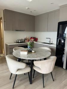 a kitchen with a table and chairs in a kitchen at 2BR Cozy Apartment- River and Park View- Masteri Centre Point - HCM in Ho Chi Minh City