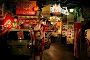 a store with signs on the side of a street at Higashi-Shinjuku 904 in Tokyo