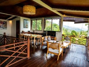 a dining room with a table and chairs and windows at Villa Borobudur Resort in Borobudur
