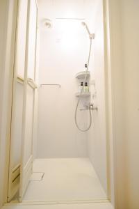 a shower in a white bathroom with a glass door at Higashi-Shinjuku 904 in Tokyo