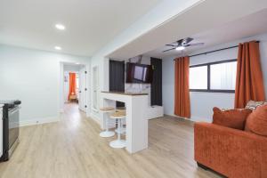 a white living room with a couch and a tv at Clearwater Bliss Apartment 3 in Clearwater Beach