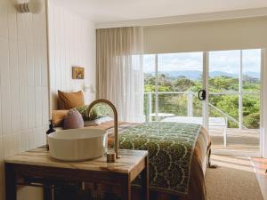 een badkamer met een wastafel, een bed en een raam bij Frankie Beach House in Bicheno