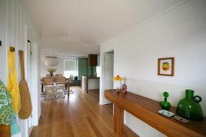 a living room with a table and a dining room at Frankie Beach House in Bicheno