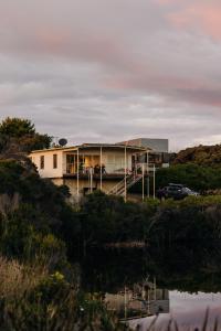 een huis op een heuvel naast een waterlichaam bij Frankie Beach House in Bicheno