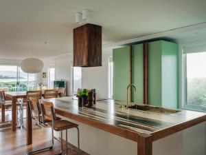 een keuken met een aanrecht met een wastafel en een aantal stoelen bij Frankie Beach House in Bicheno +24 foto's