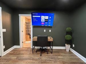 Una habitación con un escritorio y un televisor en la pared. en Rome's Escape to Modern Luxury Hidden Gem!, en Rome