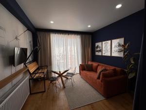 een woonkamer met een bank en een tafel bij Ski Zoo Apartments, new gudauri in Kʼumlistsʼikhe