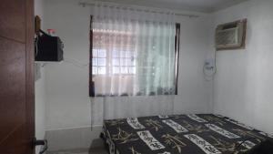 a bedroom with a bed and a window at martinshouse in Cabo Frio