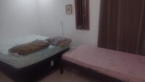 a small bed with a leopard pillow on it at martinshouse in Cabo Frio