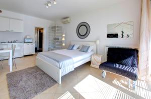 a white bedroom with a bed and a kitchen at Villa Katarina Studio Apartments in Dubrovnik