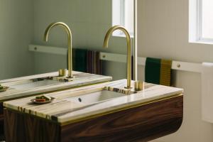 twee wastafels in een badkamer met twee spiegels bij Frankie Beach House in Bicheno