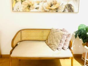 a wicker bench with a pillow on top of it at Han's Homestay by RH Splash Mania at Mayabay Residences, Gamuda Cove in Pulau Kempas +26 photos