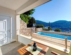a patio with a table and a swimming pool at Villa Katarina Studio Apartments in Dubrovnik