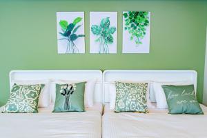 a white bed with four pictures on a green wall at Higashi-Shinjuku 904 in Tokyo