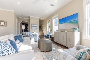 a living room with white furniture and a flat screen tv at IncogBeachO in Santa Rosa Beach
