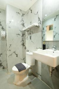 a bathroom with a toilet and a sink at Laxston Hotel in Yogyakarta