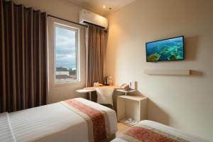a hotel room with two beds and a window at Laxston Hotel in Yogyakarta