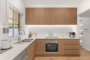 una cocina con fregadero y estufa en Inviting Single Room with Sunlit Comfort - Matraville - Shared Bathroom and Kitchen, en Sídney 27 fotos más