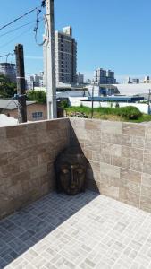 a statue of a face in a wall at Apto Perequê Sacada Frente in Porto Belo