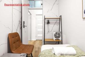 un dormitorio con una cama y una silla en Inviting Single Room with Sunlit Comfort - Matraville - Shared Bathroom and Kitchen, en Sídney