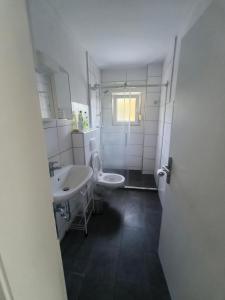 een badkamer met 2 wastafels, een toilet en een douche bij Mego Unterkünfte in Bönen