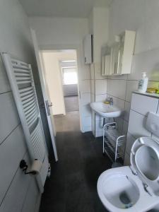 een kleine badkamer met toilet en wastafel bij Mego Unterkünfte in Bönen