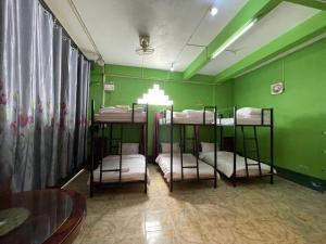 een kamer met 4 stapelbedden in een groene muur bij DP Guest-house in Pakbeng