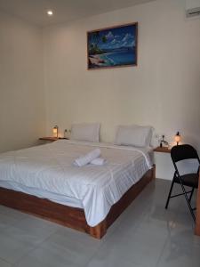 a bedroom with a large bed with two towels on it at Niviwa Guest house in Kuta Lombok