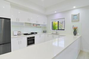 une cuisine blanche avec des armoires blanches et une fenêtre dans l'établissement King Bed w Ensuite - Sleeps 8 - Lake Aquascape, à Neranwood